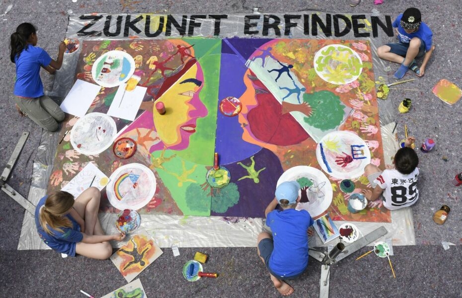 Vier Jugendliche gestalten ein Kunstwerk mit dem Titel 