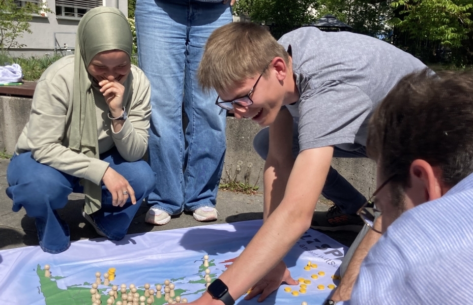 Erwachsene spielen das Eine-Welt-Spiel