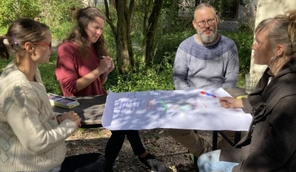 Vier Erwachsene im Garten sitzend - arbeiten thematisch