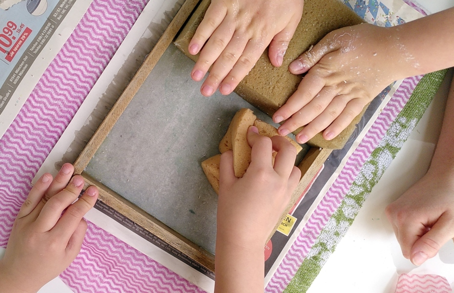 Kinderhände beim Papierschöpfen