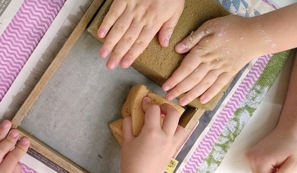 Kinderhände beim Papierschöpfen