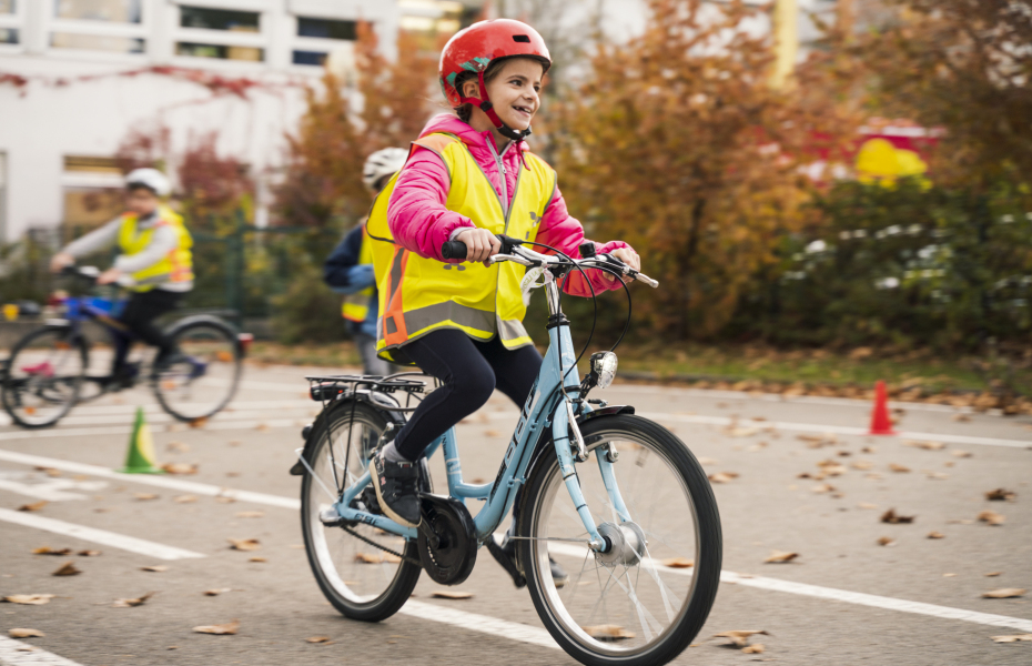 Ein Mädchen auf einem Fahrrad, fährt um kleine Hindernisse herum