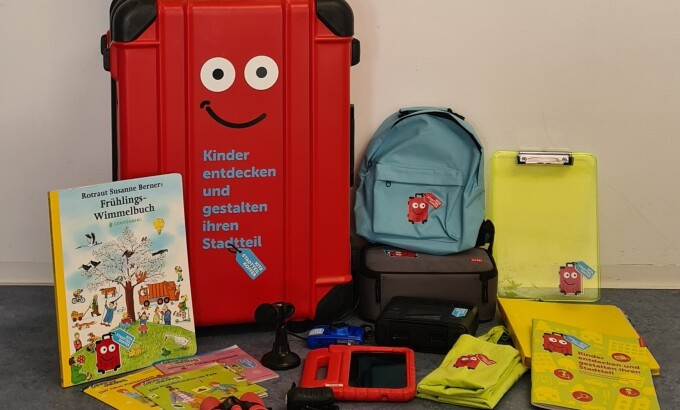 Der Inhalt des Koffers aufgebaut: Stadtpläne, Bücher, Rucksach und so weiter